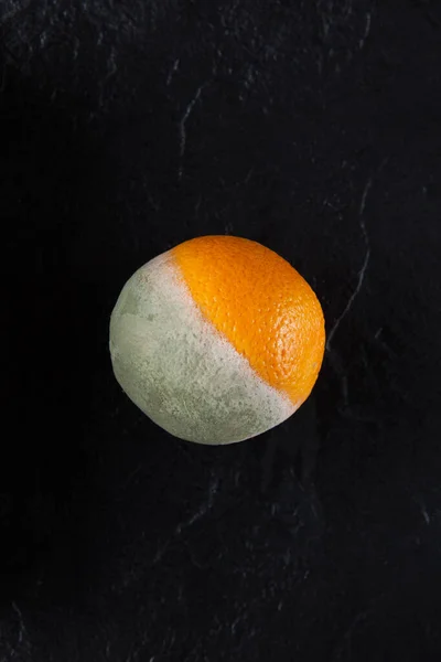 Concept Brzydkie Owoce Rozpuszczona Pomarańcza Pół Spleśniała Pomarańcza Ciemnym Tle — Zdjęcie stockowe
