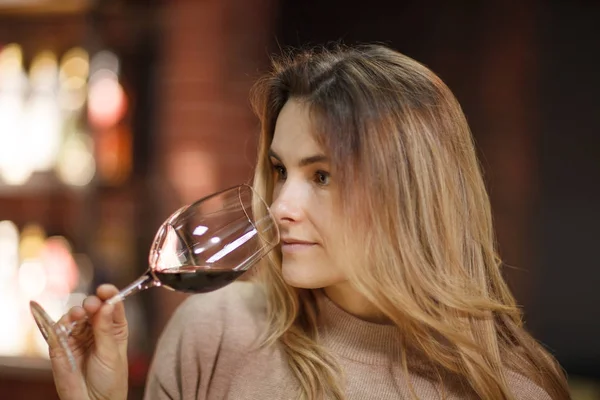 Attractive woman taste red wine in the restaurant