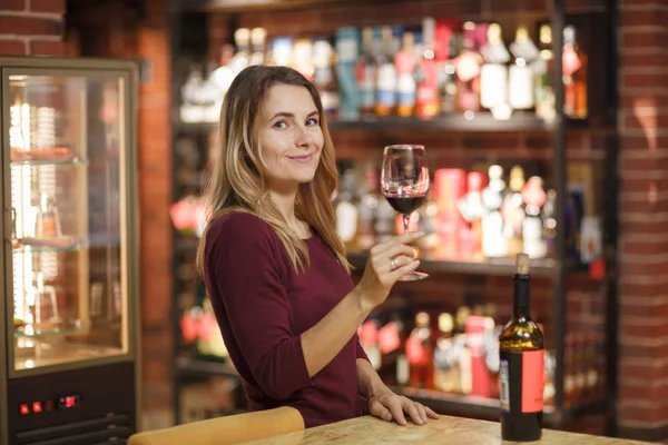 Attractive woman taste red wine in the restaurant