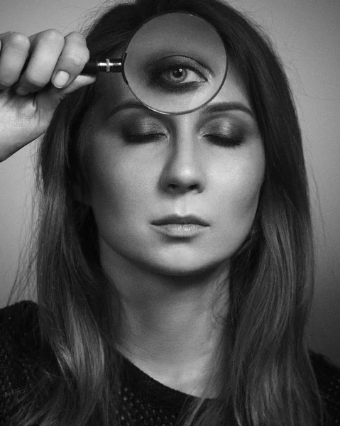 Woman see by third eye through magnifier glass. Black and white