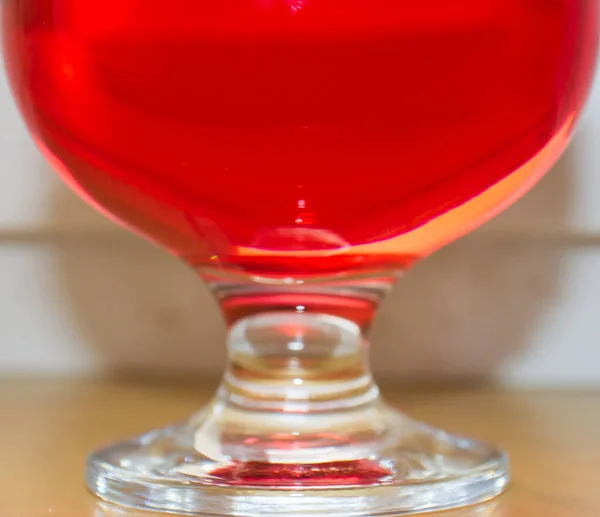 big glass of red brandy on blurred background
