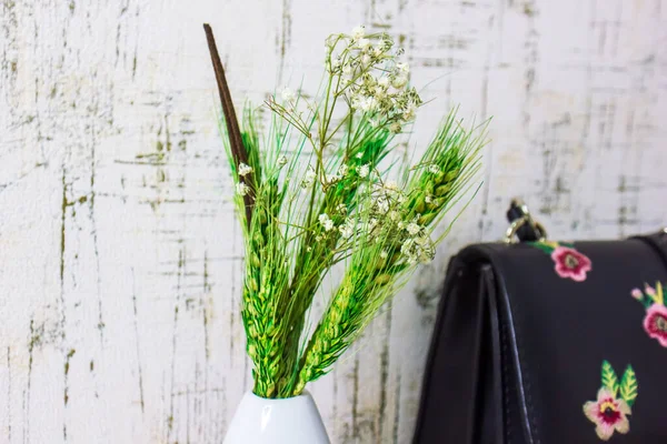 a bunch of green ears in vase on abstract background