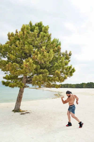 Kumsalda Genç Bir Adam Kumsalda Egzersiz Yapan Genç Kaslı Bir — Stok fotoğraf