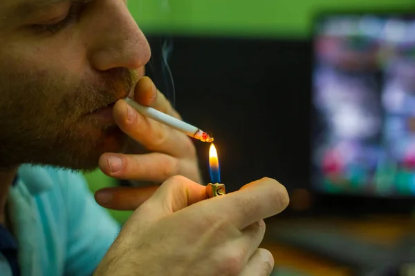 man smoking cigarette, young man smoking cigarette, young man smoking cigarette in his office at work