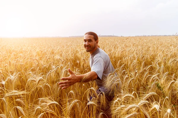 Grappige mens op gebied van tarwe reikt naar de gewenste doelgroep in de s — Stockfoto