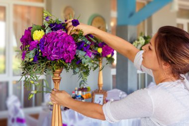 Florist at work. Woman making spring floral decorations the wedd clipart
