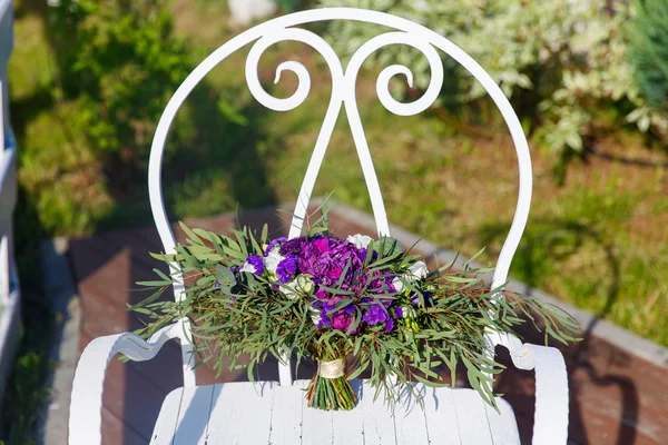 Hermoso ramo de boda en una silla de hierro forjado blanco . —  Fotos de Stock