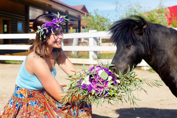 Beautiful girl feeding the straw pony on the farm. — Stock Photo, Image