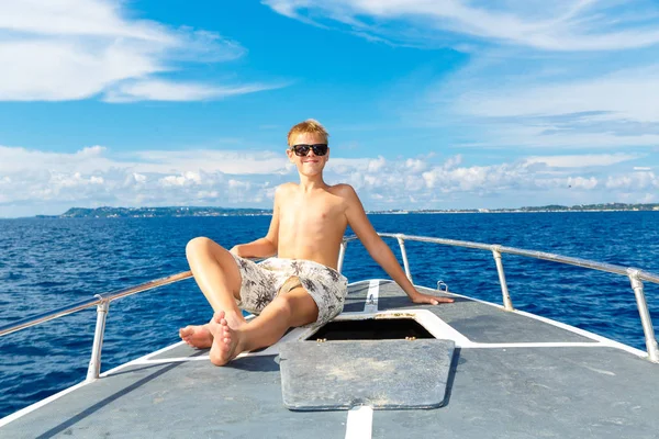 Feliz adolescente con gafas de sol en el yate. Mar tropical en el b —  Fotos de Stock