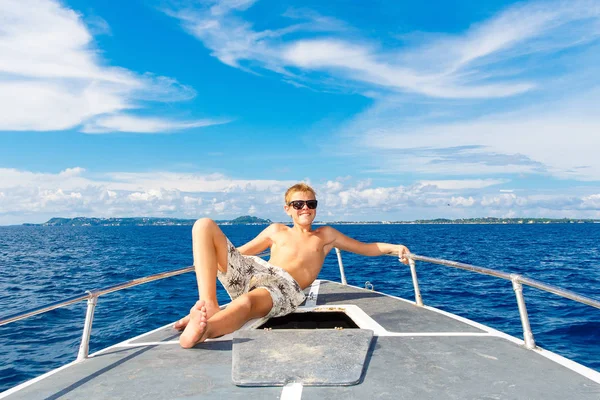 Feliz adolescente con gafas de sol en el yate. Mar tropical en el b —  Fotos de Stock