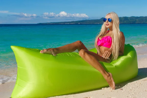 Сексуальная блондинка с длинными волосами, опирающаяся на надувной банан — стоковое фото