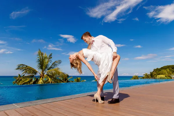 Beautiful blonde bride in white wedding dress and the groom danc — Stock Photo, Image