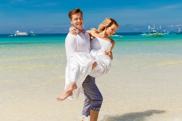 幸福的新娘和新郎在热带海滩上玩耍。热带 — 图库照片
