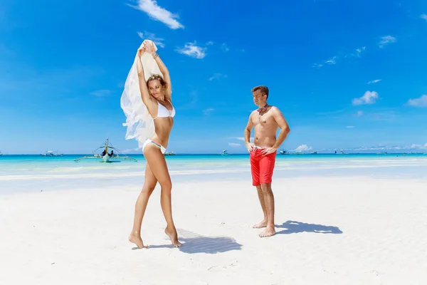 Hermosa joven novia en un bikini blanco, velo y novio que tiene f — Foto de Stock