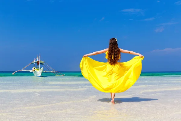 Schöne brünette Frau im gelben Kleid mit dem Rücken zum vi — Stockfoto