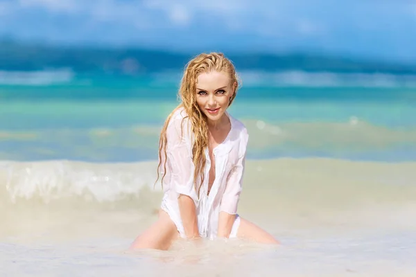 Gelukkig mooie blonde vrouw met lange haren in het wit gekleed op — Stockfoto