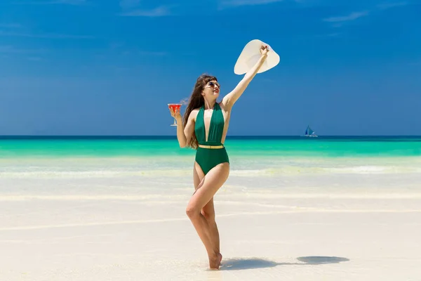 Beautiful brunette in a straw hat with a martini glass on the sh — Stock Photo, Image