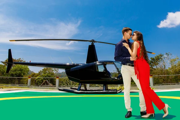 Joven hombre elegante en gafas de sol y una mujer en rojo de pie al lado —  Fotos de Stock