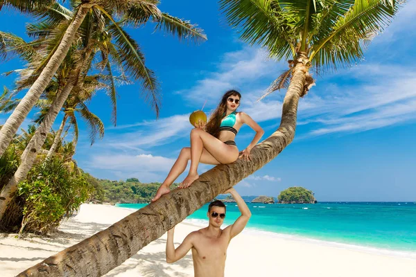 Jovem casal amoroso em uma palmeira em uma praia tropical. Tropical — Fotografia de Stock