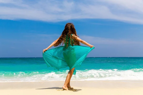 Tropikal bir plajda mavi elbiseli genç güzel kız — Stok fotoğraf