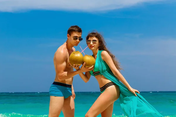 Jovem casal amoroso beber coco na praia tropical. Verão vaca — Fotografia de Stock