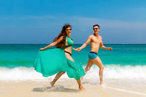 Молодая любящая пара веселится на тропическом пляже. Летние каникулы — стоковое фото