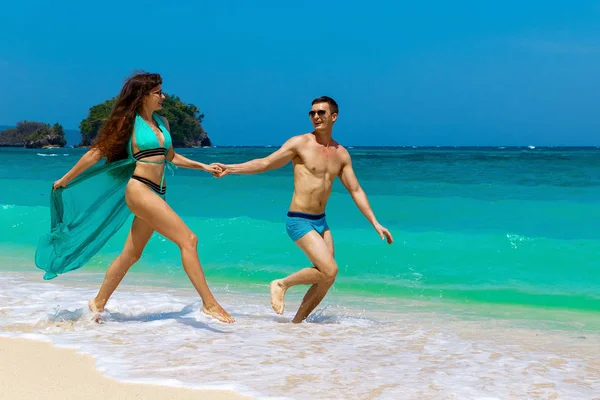 Jovem casal amoroso se divertindo na praia tropical. Veraneio — Fotografia de Stock