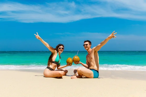 Mladá milující pár vypijte kokosové na tropické pláži. Letní vaca — Stock fotografie