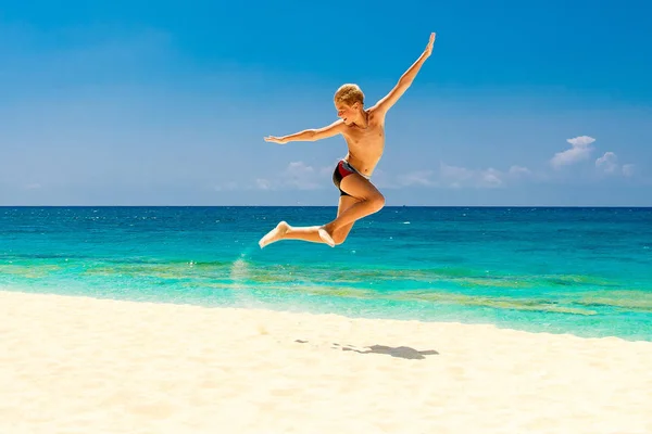 Счастливый мальчик-подросток веселится на тропическом пляже. Летний отдых — стоковое фото