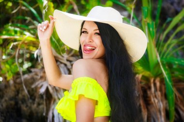 Üzerinde bikini ve saman şapkalı uzun saçlı güzel esmer