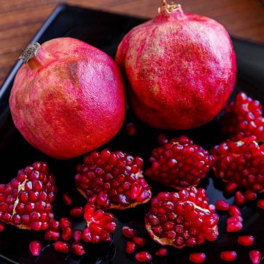 Biraz olgun sulu kırmızı nar meyve plaka üzerinde. (Punica gran