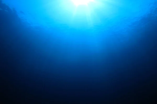 Deep blue ocean water with shining sunrays