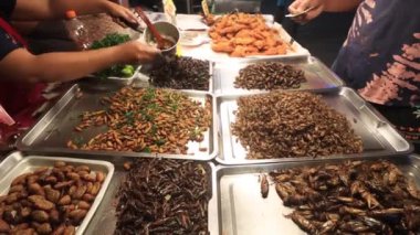Akrepler, böcekler, çekirgeler, çekirgeler, kurbağalar ve böcekler Asya sokak pazarında pişirilip satıldı. Böcekler iyi protein kaynaklarıdır.