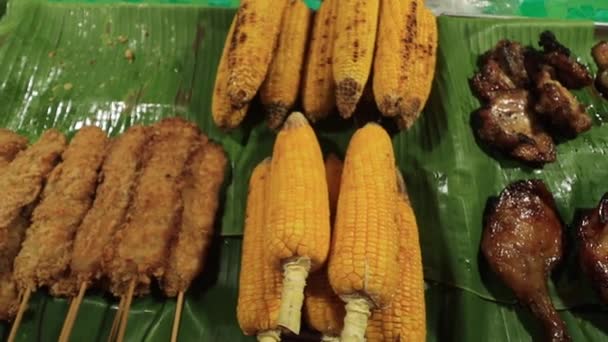 焼きバーベキューが広がります バナナの葉に肉 トウモロコシ ストリートマーケット Bbq — ストック動画