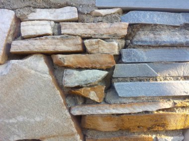 Çimento arkaplan dokusuna sahip gri ve turuncu taş duvar yüzeyi