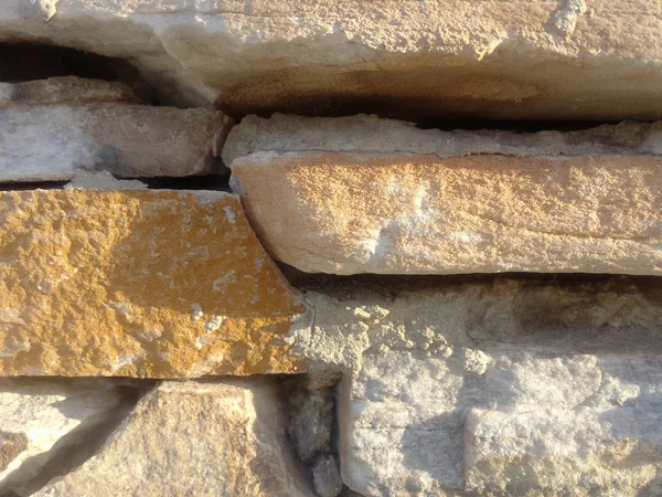 Gri ve turuncu taş duvar. Güneş ışığı detay arkaplan dokusu. 