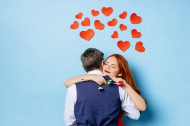 Mavi arka planda izole edilmiş güzel bir çiftin portresi.