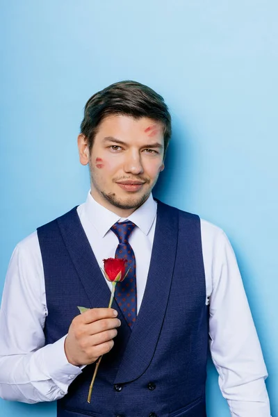 Hombre caucásico barbudo con flores aisladas sobre fondo azul —  Fotos de Stock