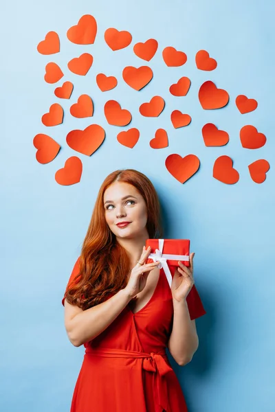 dreamy woman with gift isolated over blue background