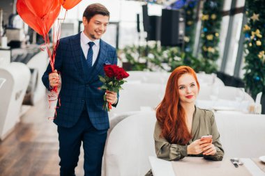 Smokinli zarif beyaz adam ve kızıl saçlı kadın.