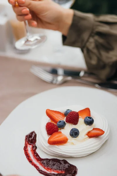 Pyszny deser pavlova na białym talerzu z bezy, śmietany i świeżych owoców — Zdjęcie stockowe