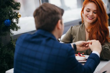 Genç adam kız arkadaşına evlenme teklif ediyor.