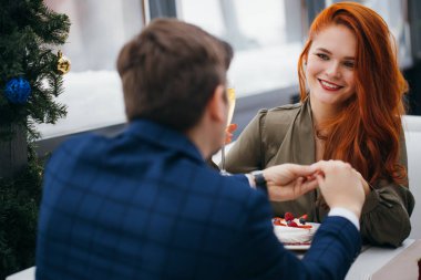 Genç adam kız arkadaşına evlenme teklif ediyor.