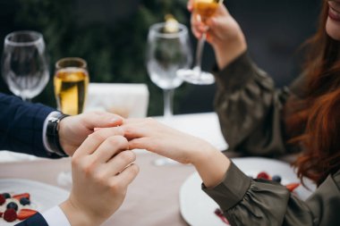 Yakın plan erkek, kadına evlenme teklif eder, parmağına yüzük takar.