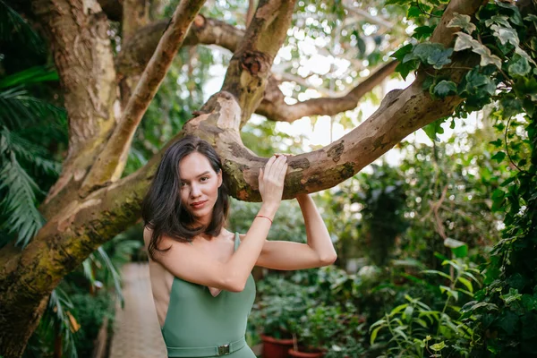 Mulher bonita esbelta entre plantas tropicais — Fotografia de Stock