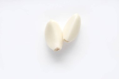 Beyaz arka planda soyulmuş iki sarımsak.