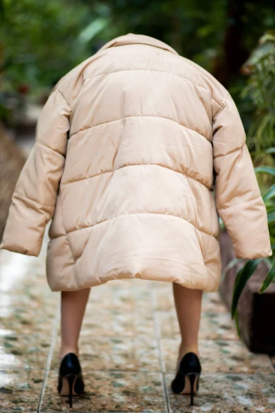 Achteraanzicht op kleine vrouw dwerg gekleed in beige jas — Stockfoto