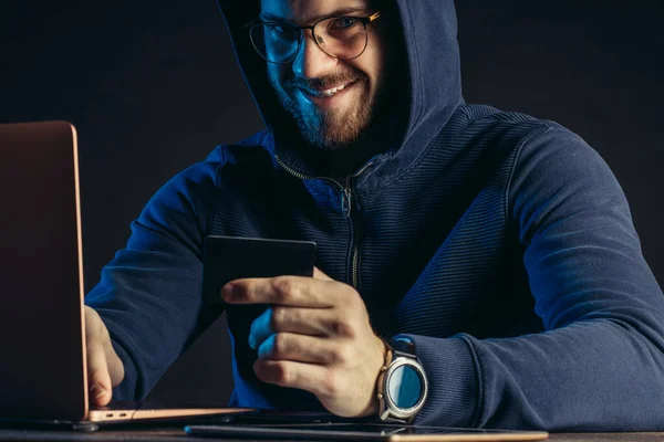 Astuto hombre hacker sonriente tiene tarjeta bancaria en la mano — Foto de Stock