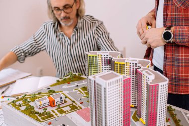 Kıdemli mimar stajyerlerin çalışmalarını izliyor
