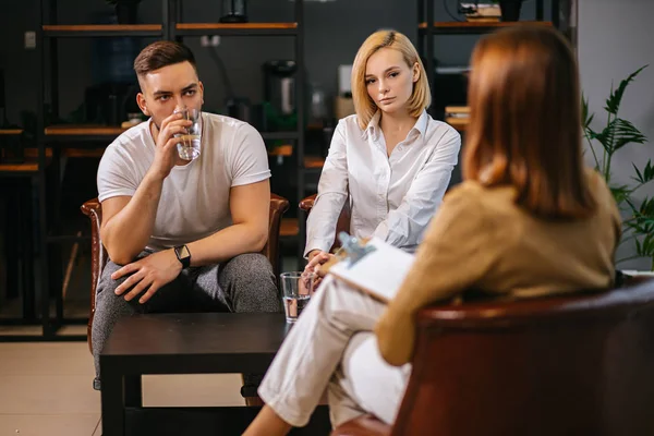 Rodinný nesouhlas. mladí manželé diskutují o svých problémech na manželské terapii s psychologem — Stock fotografie